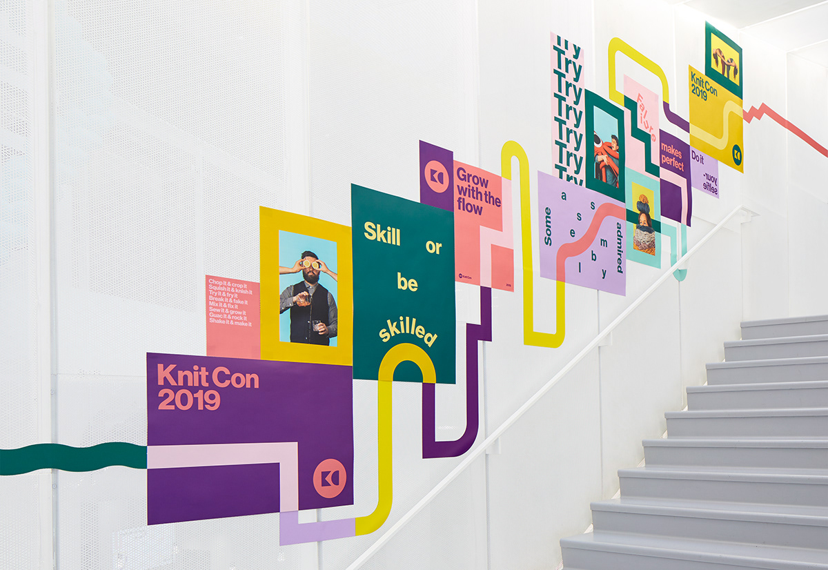 Colorful posters on a white wall as you walk up the staircase showcasing Knit Con, a Pinterest conference
