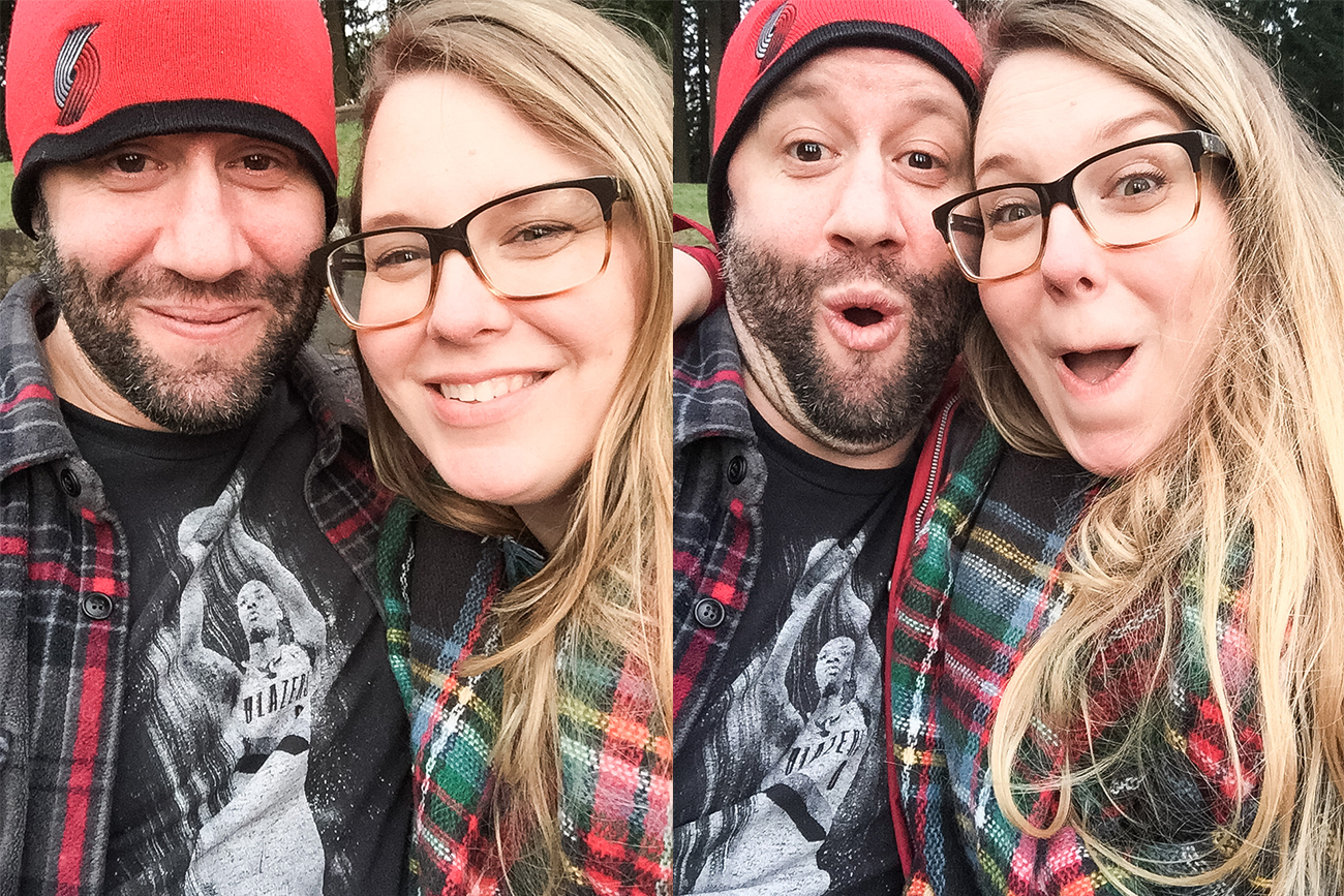 A blonde girl wearing a plaid scarf and a man with a beard and red beanie making faces and smiling